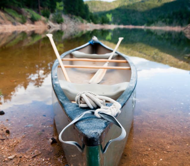 The canoe is anchored by the lake