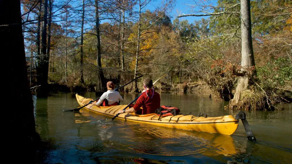 The tandem kayak is being hung by 2 people