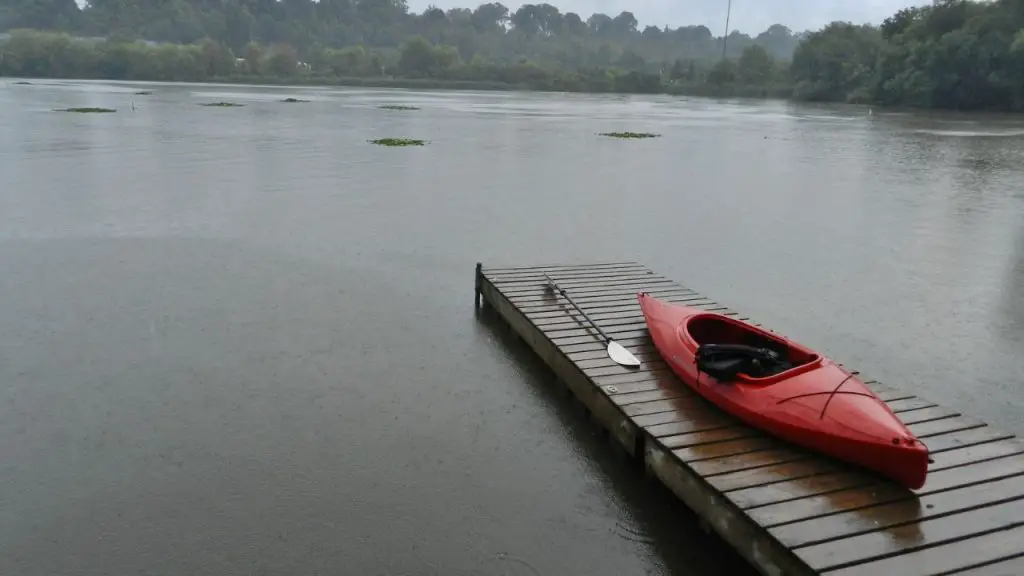 A red kayak on the bridge in the rain