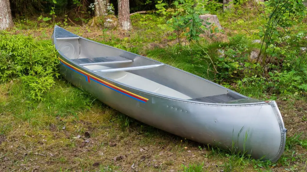Aluminum canoe lying on the grass