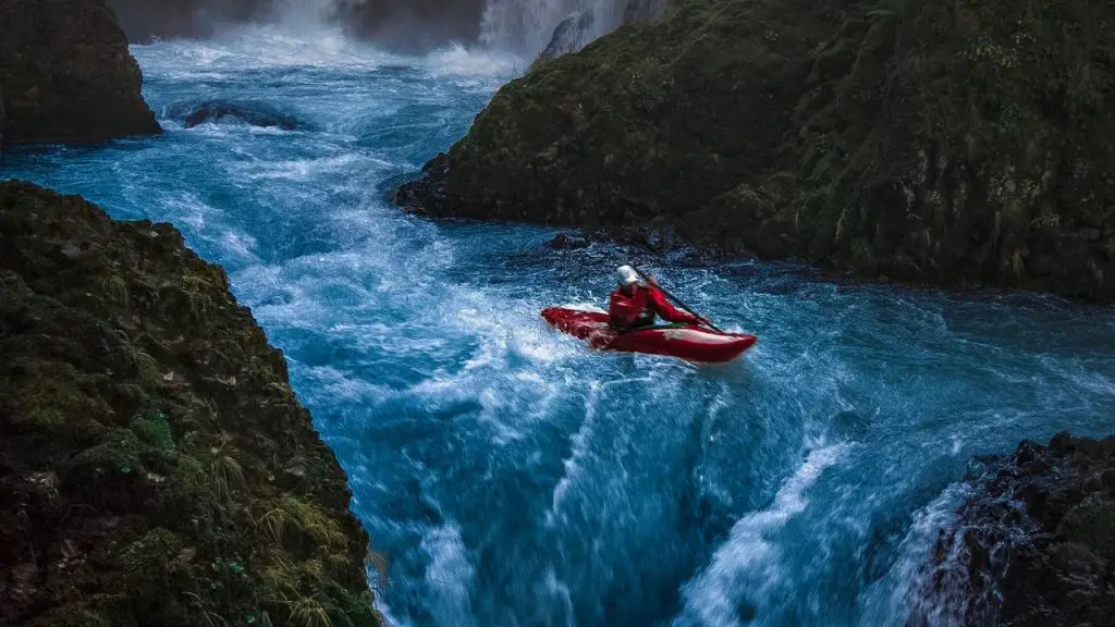 Person on kayak and near Waterfall