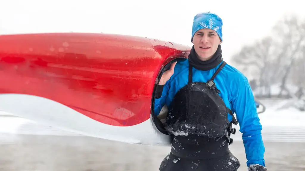 Sportsman holding kayak on cold weather