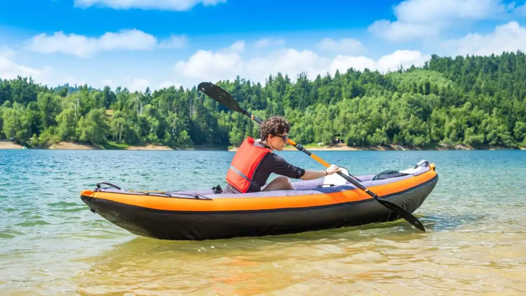 The man is rowing inflatable kayak 