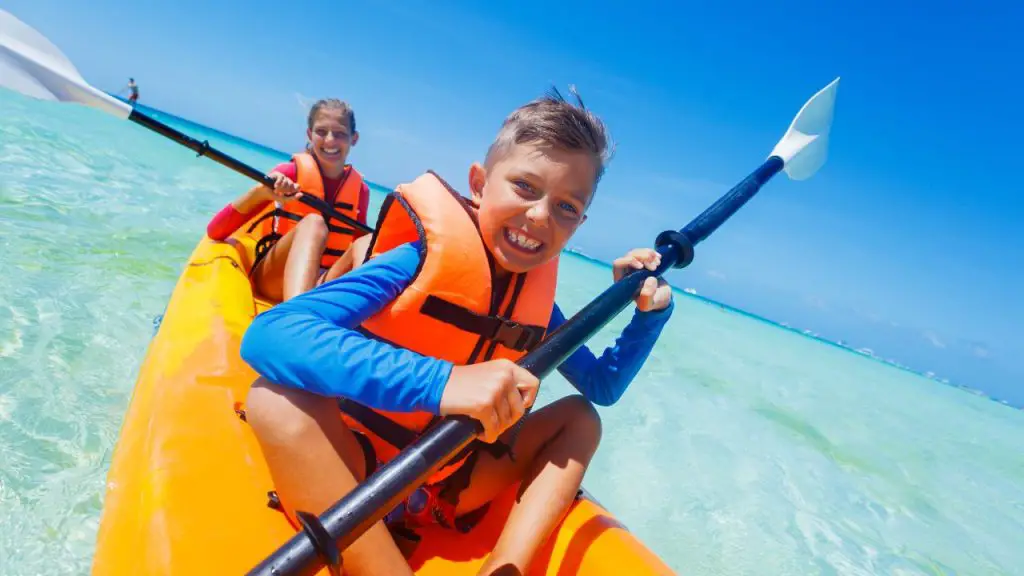 kids are laughing while kayaking