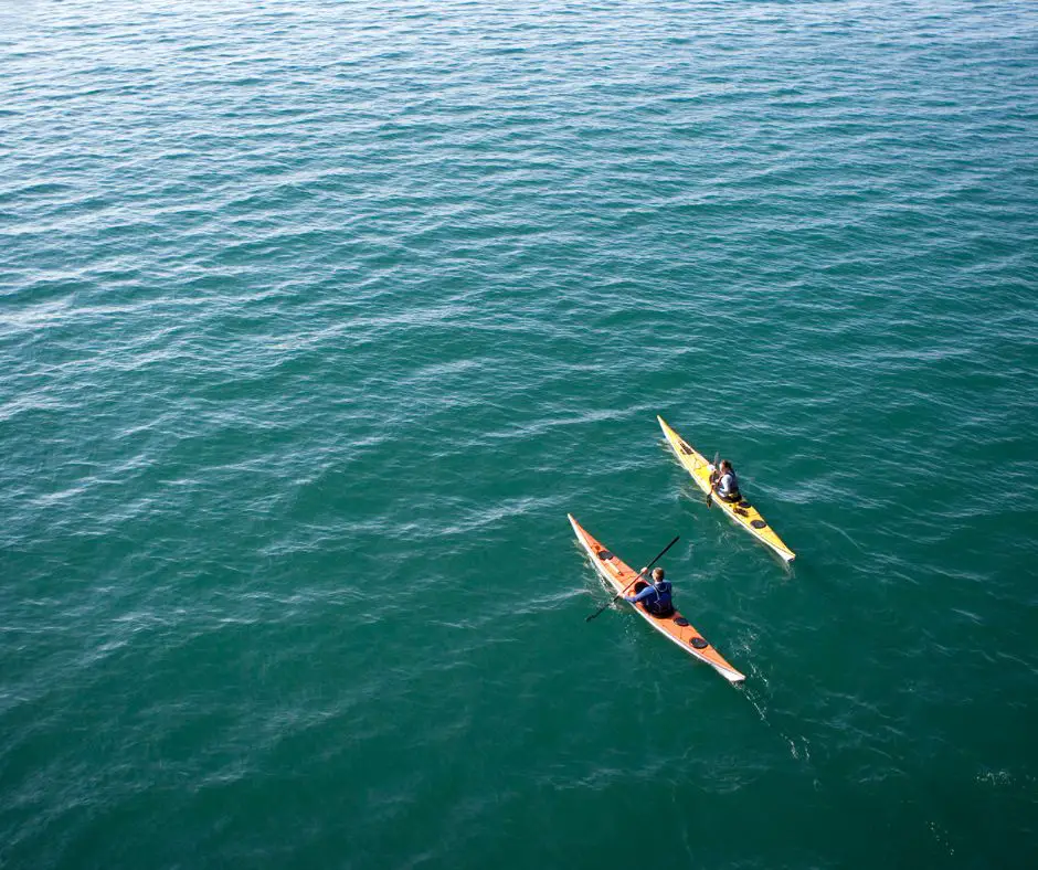 A couple is paddling kayak on the sea