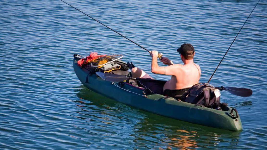 A guy is fishing on the kayak