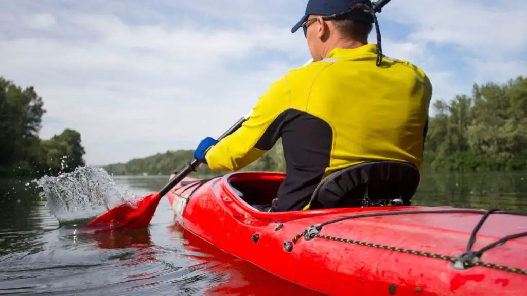 A man is red kayaking on the river