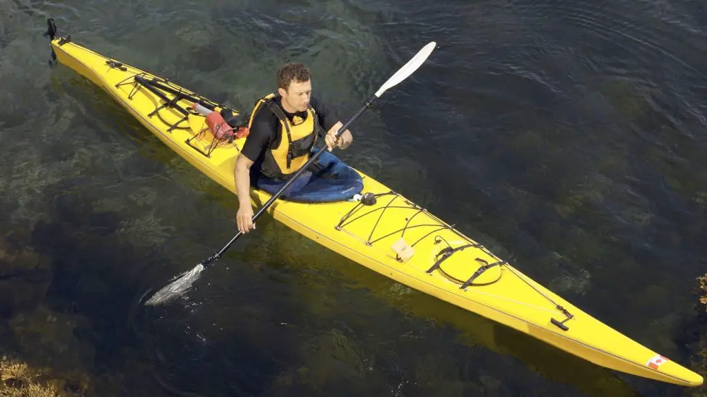 A man is yellow kayaking with a spray skirt