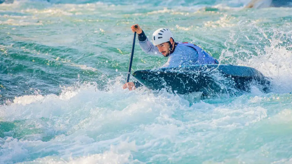 A man professionally kayaking in white water