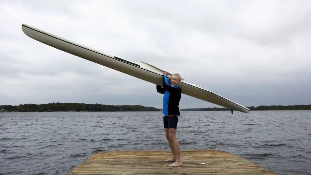 Middle-Aged Woman with Kayak Standing by Lake