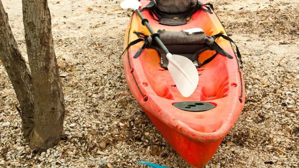 Old red kayak lying on the open ground