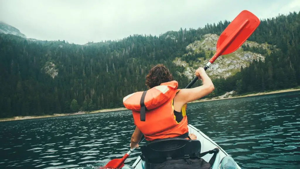 a girl is having a hard time kayaking in windy weather