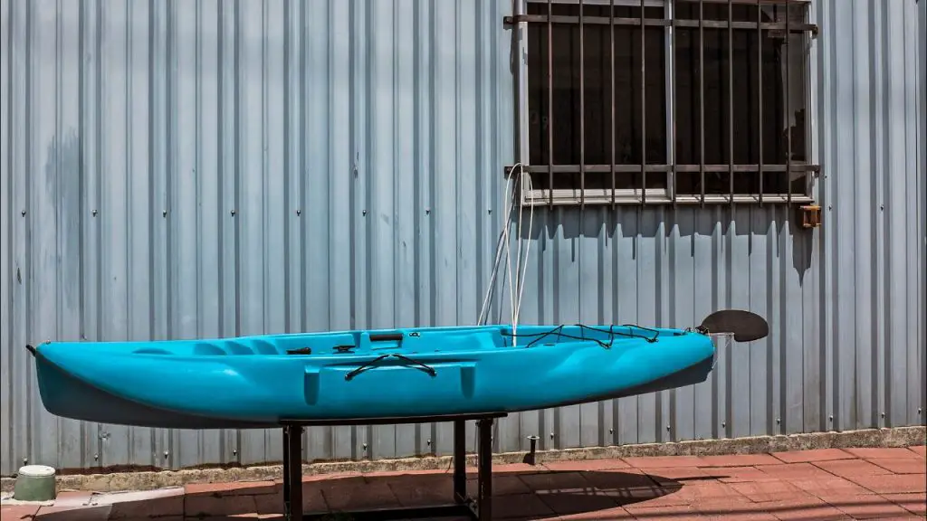 the blue kayak is being locked by the rope next to the window