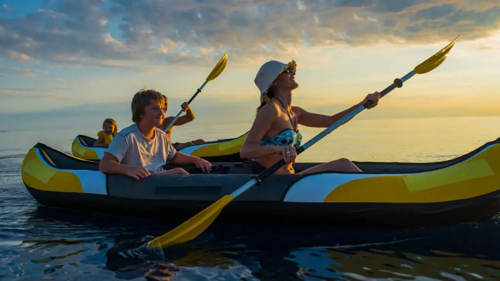 A family is paddling inflatable kayaks in the sea