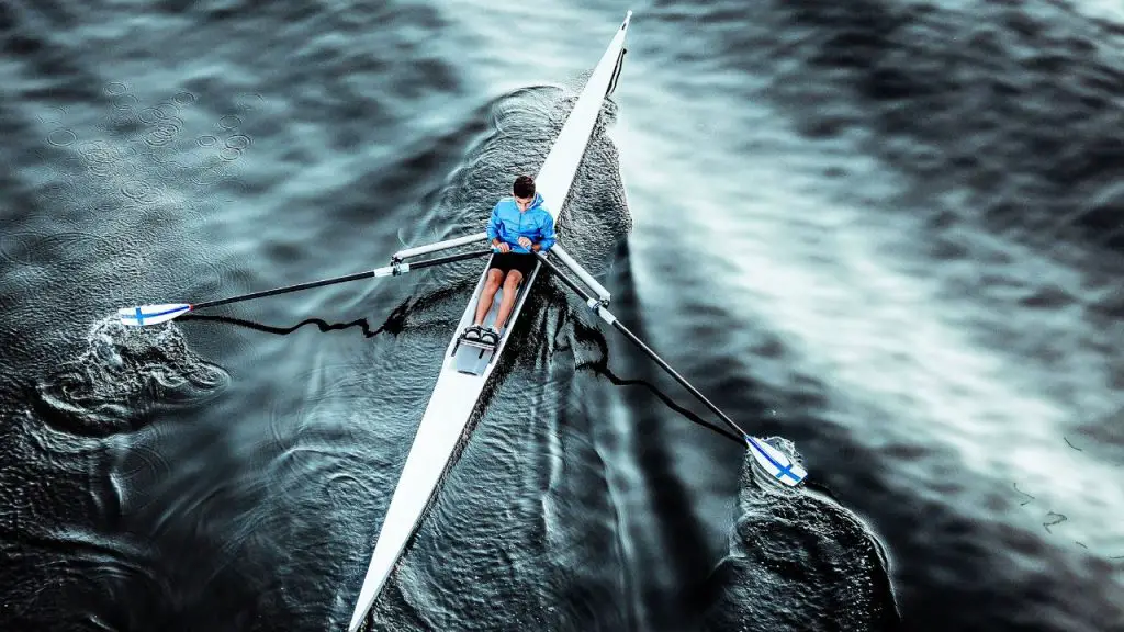 A man uses a long paddle when kayaking