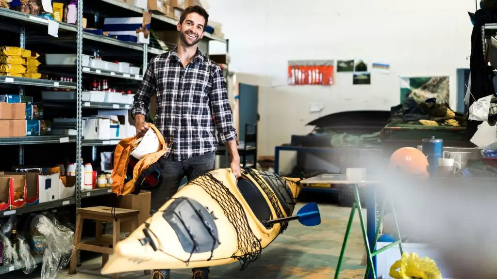 A man prepares to clean kayak before storage