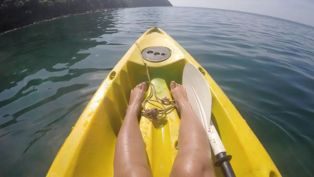 Kayaker is padding with barefoot