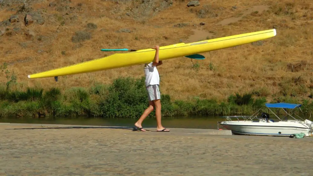 Man is carrying a kayak