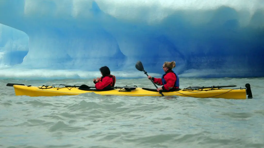 Two girls are paddling tandem kayaking with the cold weather