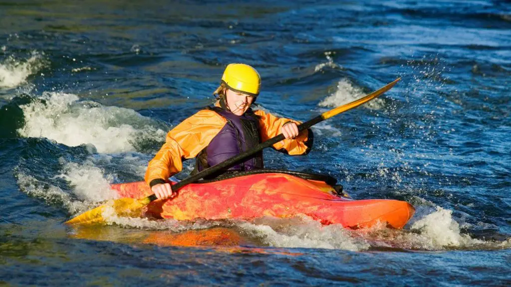 A man is paddling upstream kayak