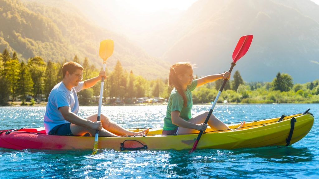a couple are kayaking in summer